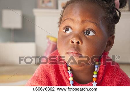 Stock Image - Close up portrait of female toddler looking sideways. Fotosearch