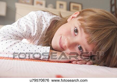 Close up portrait of girl lying on rug View Large Photo Image Stock Photograph - Close up portrait of girl lying on rug. Fotosearch