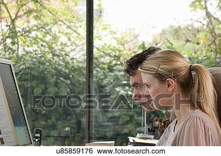 Couple at home staring at computer screen View Large Photo Image Stock Photograph - Couple at home staring at computer screen. Fotosearch