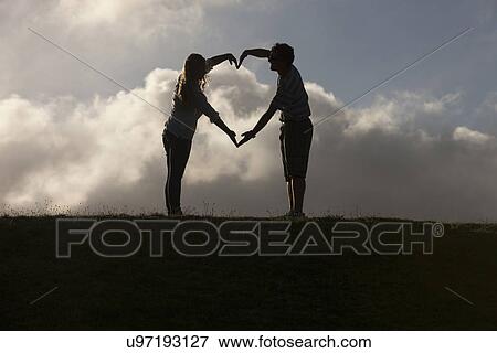 Couple forming heart shape with hands View Large Photo Image Stock Photo - Couple forming heart shape with hands. Fotosearch