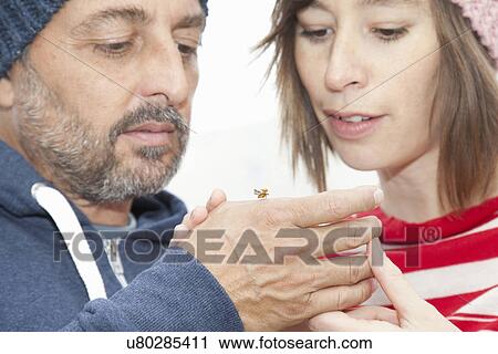 Stock Image - Couple looking at insect. Fotosearch