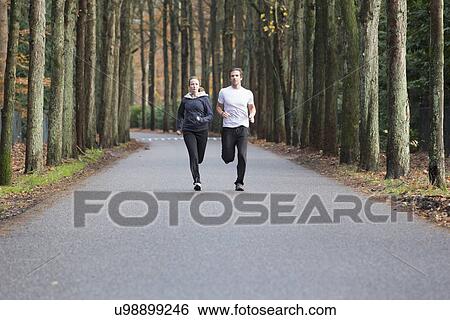 Couple running through forest View Large Photo Image Stock Photograph - Couple running through forest. Fotosearch