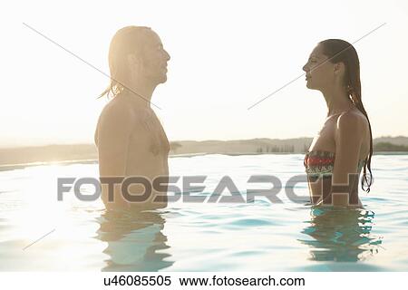 Couple standing, facing each other in outdoor swimming pool View Large Photo Image Stock Photography - Couple standing, facing each other in outdoor swimming pool. Fotosearch