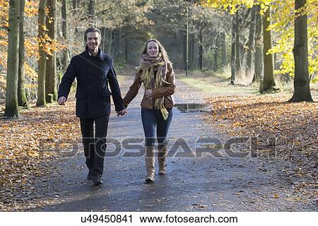 Stock Image - Couple walking through forest. Fotosearch