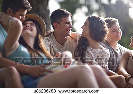 Stock Image - Couples chatting in forest. Fotosearch