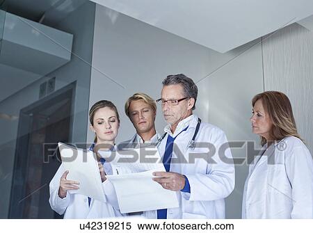 Stock Photography -  Doctors discussing medical notes. Fotosearch