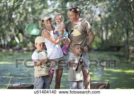 Stock Image - Family on fishing trip by stream. Fotosearch