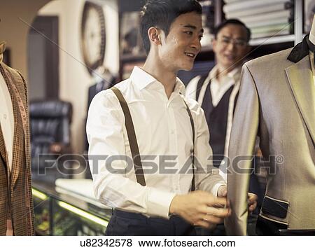 Father and son at work in family tailors shop View Large Photo Image Stock Photo - Father and son at work in family tailors shop. Fotosearch