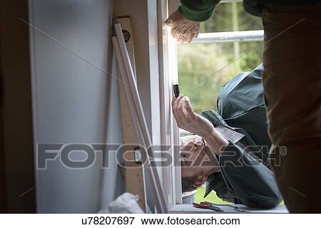 Father and son builders adjusting new window in house, close up View Large Photo Image Stock Photo - Father and son builders adjusting new window in house, close up. Fotosearch