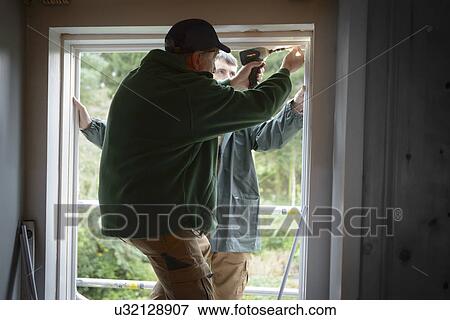 Father and son builders installing new window in house View Large Photo Image Stock Photo - Father and son builders installing new window in house. Fotosearch