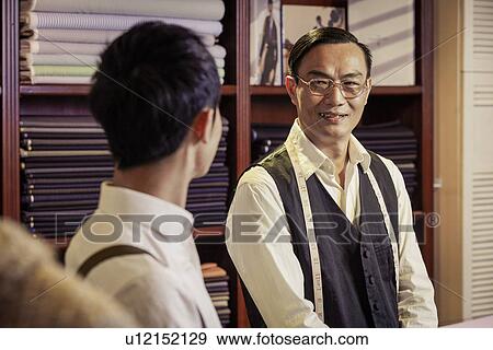 Father and son in family tailors shop View Large Photo Image Stock Photo - Father and son in family tailors shop. Fotosearch