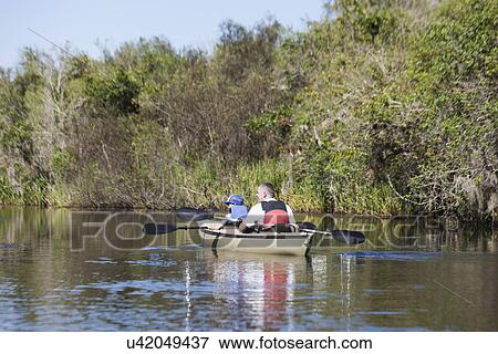 Stock Photo - Father and son watching from boat, Everglades, Florida, USA. Fotosearch