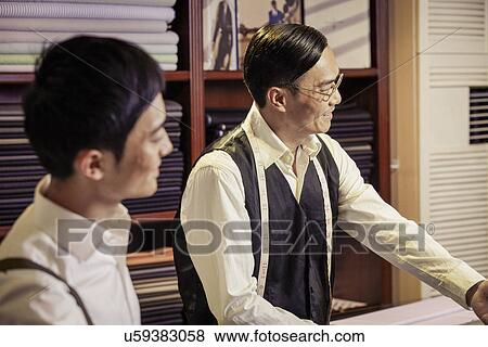 Father and son working in family tailors shop View Large Photo Image Stock Photo - Father and son working in family tailors shop. Fotosearch