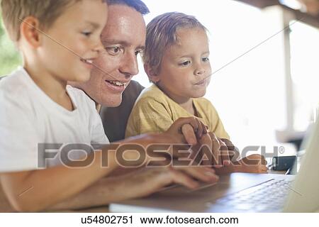 Father and sons using laptop View Large Photo Image Stock Image - Father and sons using laptop. Fotosearch
