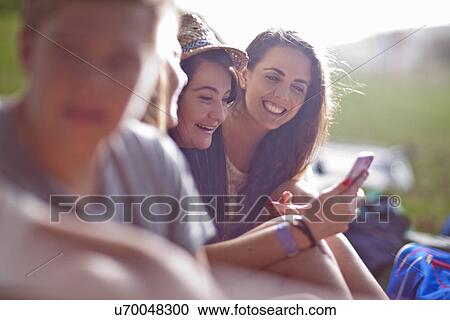 Friends chatting, using cellular phone View Large Photo Image Stock Image - Friends chatting, using cellular phone. Fotosearch