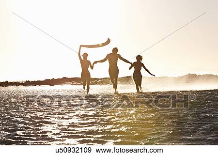 Friends running in sea View Large Photo Image Stock Photo - Friends running in sea. Fotosearch