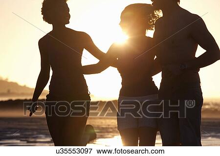 Friends walking by seaside View Large Photo Image Stock Photo - Friends walking by seaside. Fotosearch