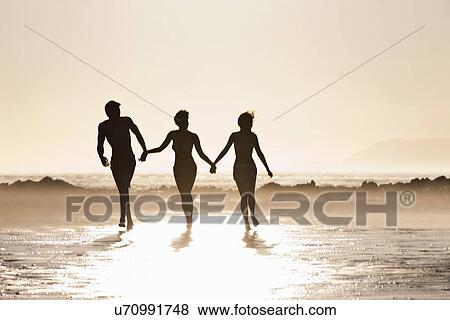 Friends walking by seaside View Large Photo Image Stock Photo - Friends walking by seaside. Fotosearch