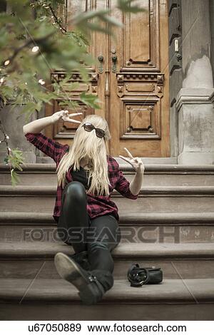 Fun young woman hiding behind her long blond hair on steps View Large Photo Image Stock Photo - Fun young woman hiding behind her long blond hair on steps. Fotosearch