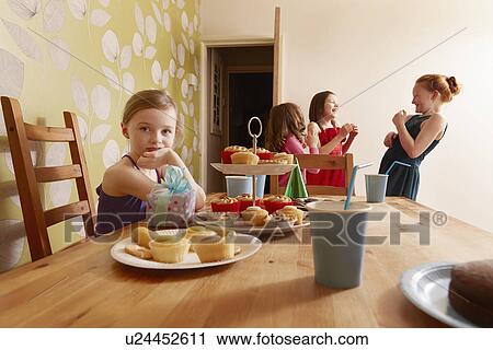 Girl at table with party food, friends in background View Large Photo Image Stock Image - Girl at table with party food, friends in background. Fotosearch