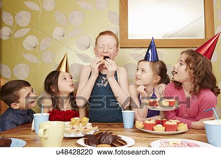Girl eating party food with friends watching View Large Photo Image Stock Image - Girl eating party food with friends watching. Fotosearch