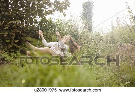 Girl having fun on garden swing View Large Photo Image Stock Photography - Girl having fun on garden swing. Fotosearch
