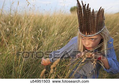 Girl hiding in long grass dressed up as a native american View Large Photo Image Stock Image - Girl hiding in long grass dressed up as a native american. Fotosearch