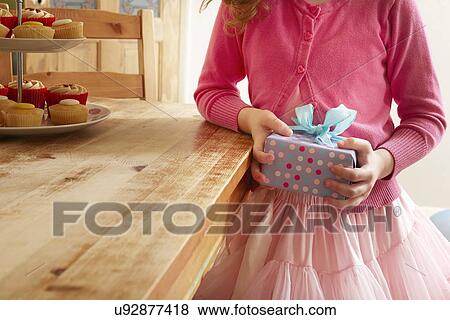 Girl holding birthday present, mid section View Large Photo Image Stock Photo - Girl holding birthday present, mid section. Fotosearch