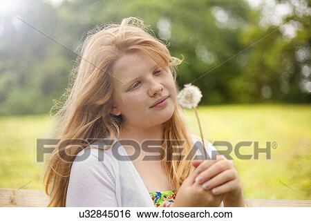 Girl holding dandelion clock View Large Photo Image Stock Photograph - Girl holding dandelion clock. Fotosearch