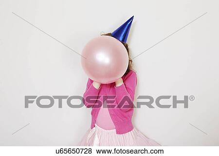 Stock Photo - Girl holding pink balloon in front of face. Fotosearch