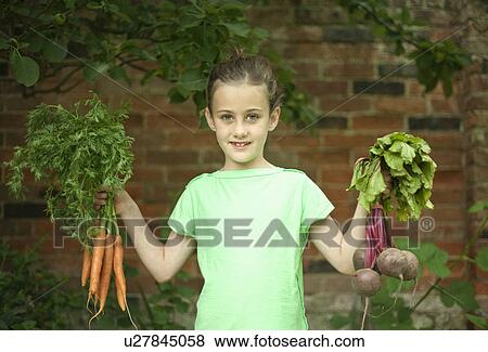 Girl holding up bunches of carrots and beetroots View Large Photo Image Stock Photo - Girl holding up bunches of carrots and beetroots. Fotosearch