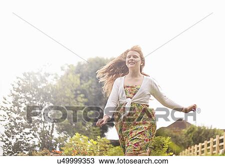 Stock Image - Girl running in garden. Fotosearch