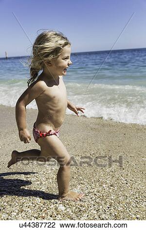 Stock Image - Girl running on beach. Fotosearch