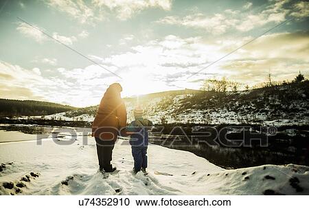 Stock Image - Grandmother and young grandson enjoying rural winter landscape. Fotosearch