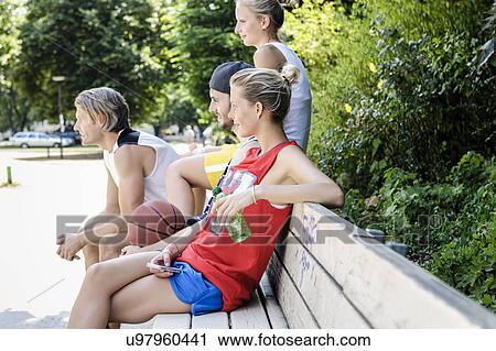 Group of basketball friends taking a break in park View Large Photo Image Stock Image - Group of basketball friends taking a break in park. Fotosearch