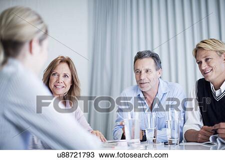 Group of businessmen and women holding a meeting View Large Photo Image Stock Image - Group of businessmen and women holding a meeting. Fotosearch