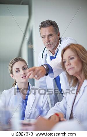 Group of doctors having a serious meeting in conference room View Large Photo Image Stock Image - Group of doctors having a serious meeting in conference room. Fotosearch