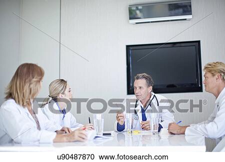 Stock Image - Group of doctors holding a meeting. Fotosearch