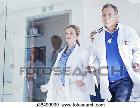 Group of doctors rushing along corridor to emergency View Large Photo Image Stock Photo - Group of doctors rushing along corridor to emergency. Fotosearch
