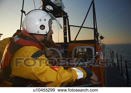 Stock Photo - Lifeboat crew training on lifeboat at sea. Fotosearch