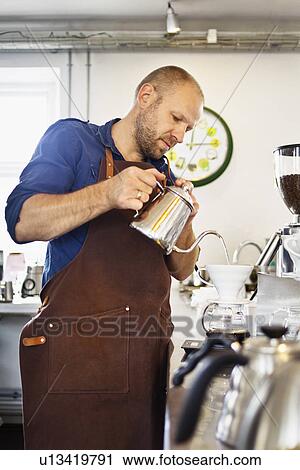 Male barista pouring boiling water into coffee filter View Large Photo Image Stock Image - Male barista pouring boiling water into coffee filter. Fotosearch