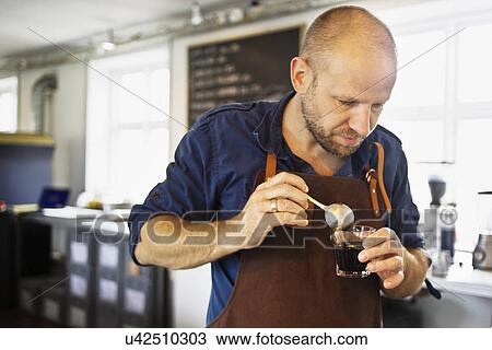Male barista stirring coffee glass in coffee bar View Large Photo Image Stock Image - Male barista stirring coffee glass in coffee bar. Fotosearch