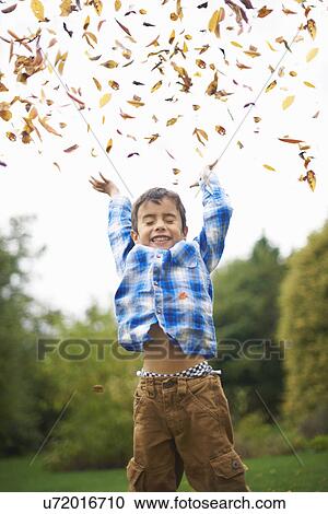 Male toddler in the garden throwing up autumn leaves View Large Photo Image Stock Image - Male toddler in the garden throwing up autumn leaves. Fotosearch