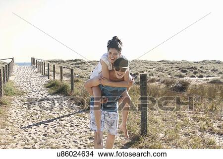 Man giving young woman piggyback, Port Melbourne, Melbourne, Australia View Large Photo Image Picture - Man giving young woman piggyback, Port Melbourne, Melbourne, Australia. Fotosearch
