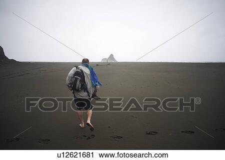 Man walking on Karekare beach, Karekare, New Zealand View Large Photo Image Stock Image - Man walking on Karekare beach, Karekare, New Zealand. Fotosearch