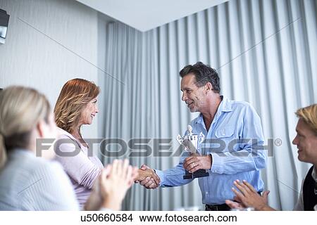 Mature businesswomen receiving trophy at meeting View Large Photo Image Picture - Mature businesswomen receiving trophy at meeting. Fotosearch