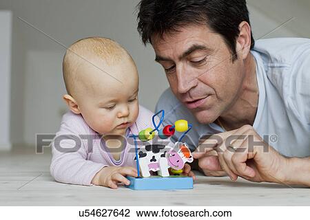 Mature man and baby daughter playing with toy cow View Large Photo Image Stock Image - Mature man and baby daughter playing with toy cow. Fotosearch