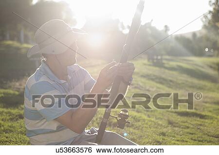 Stock Photograph - Mature man holding fishing rod. Fotosearch