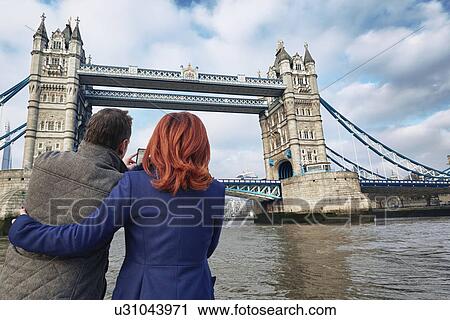 Mature tourist couple photographing Tower Bridge, London, UK View Large Photo Image Stock Image - Mature tourist couple photographing Tower Bridge, London, UK. Fotosearch