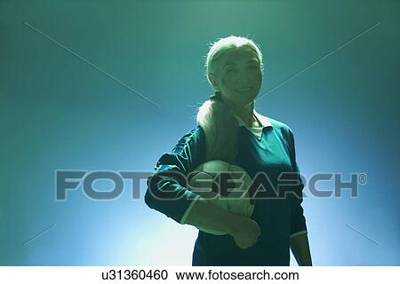 Mature woman holding football, backlit View Large Photo Image Stock Image - Mature woman holding football, backlit. Fotosearch